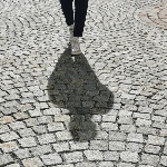 Schatten auf Kopfsteinpflaster im Gegenlicht